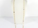 un collier à chaîne en or composé de maillons longs et muni d'un fermoir circulaire