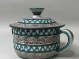 a blue and white pot with a lid on a table
