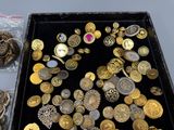 a black box filled with lots of gold and silver buttons