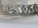 a silver plate with a design on it on a table