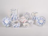 several pieces of blue and white porcelain are arranged on a white surface