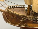 une maquette en bois d'un bateau muni d'une voile