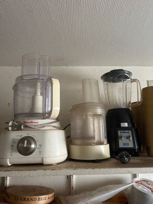 une étagère sur laquelle se trouvent un mixeur, un mixeur, un mixeur et d'autres ustensiles de cuisine