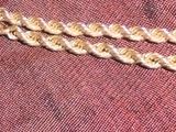 un gros plan d'un collier en or posé sur un tissu rouge