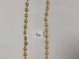 un collier en or avec une chaîne à maillons ronds sur fond blanc