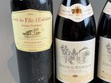 three bottles of red wine sit next to each other on a table