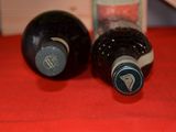two bottles of wine sitting on a red table