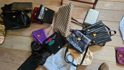 de nombreux sacs à main et sacs posés par terre à côté d'une chaise