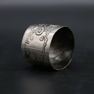 a close up of a silver ring on a black surface