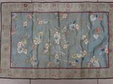 an old chinese rug on a tiled floor with a blue background