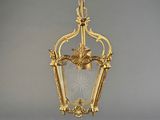 an antique brass hanging light fixture with a clear glass shade