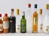 de nombreuses bouteilles d'alcool alignées sur une surface blanche
