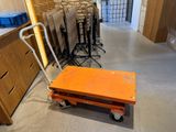 an orange cart with a handle in the middle of a room