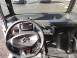 a steering wheel and dashboard of a vehicle in a parking lot