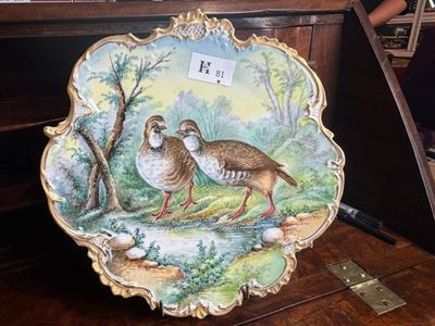une assiette sur laquelle sont peints deux oiseaux, posée sur une table