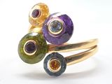 a close up of a ring with different colored stones on it