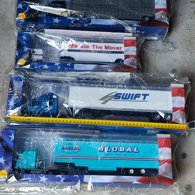 quatre types différents de petits trains jouets dans des sacs posés par terre