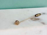 la broche en or repose sur un comptoir en marbre