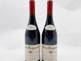 deux bouteilles de vin rouge posées l'une à côté de l'autre sur une surface blanche