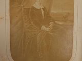 an old photo of a woman sitting in a chair in a room