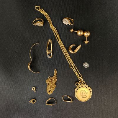 certains bijoux en or sont disposés sur une surface noire