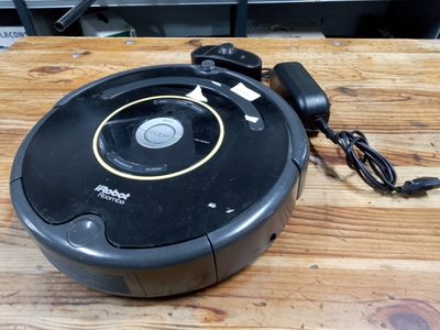 a robotic vacuum on a wooden table with a charger