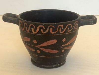 un vase noir et rouge posé sur une table