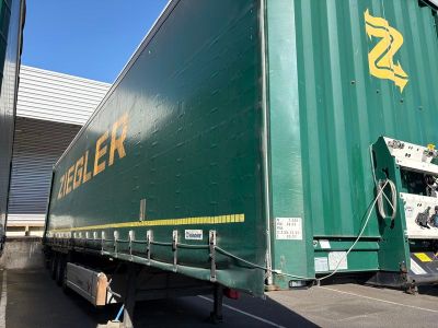 un gros camion vert garé sur un parking