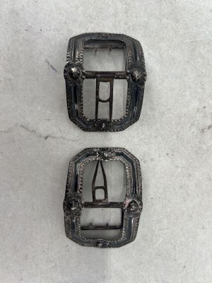 deux boucles en métal noir sur un fond blanc