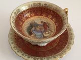 a cup and saucer with a painting on it