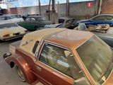 several old cars are parked in a parking lot near a building