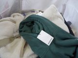 a pile of clothes sitting on a bed with a tag on it