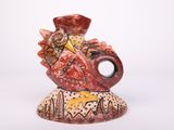 a small vase with a bird on it on a white surface