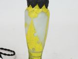 a yellow vase with a blue base and a black top