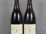 Deux bouteilles de vin sont posées sur une table en verre.