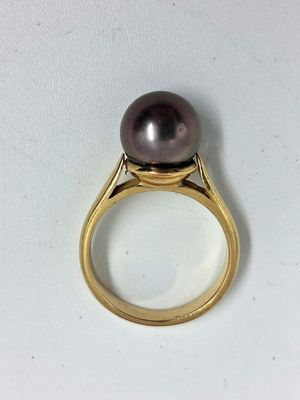 un gros plan d'une bague ornée d'une perle noire