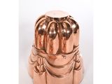 un moule à gâteau en métal posé sur une surface blanche