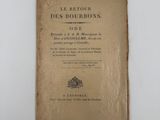 un vieux livre posé sur une table à côté d'un mur blanc