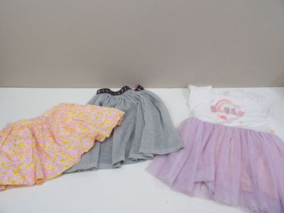 two dresses and a t - shirt are sitting on a white table