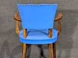 a blue chair with wooden legs and a blue seat