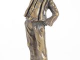 bronze statue of a man with a hat and tie standing on a block