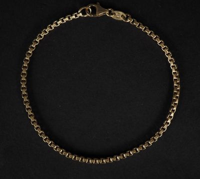 un bracelet en chaîne en or sur fond noir
