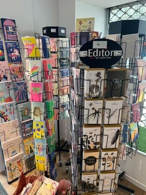 un présentoir de cartes de vœux dans un magasin, près d'une vitrine