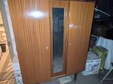 une armoire en bois surmontée d'un miroir, dans une pièce