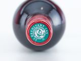 a close up of a bottle of wine on a white surface