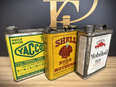 three old oil cans are sitting on a table next to each other