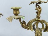 a gold colored candle holder with a bird on it