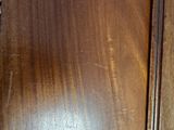 a cat that is sitting on the floor in front of a dresser