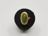 Gros plan sur une bague contenant une pierre verte