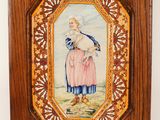 an old picture of a woman in a pink dress is hanging on a wall